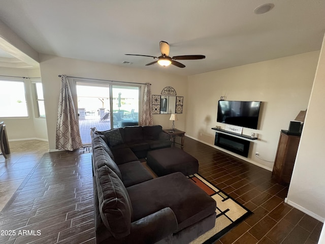 living area with ceiling fan, baseboards, and wood finish floors