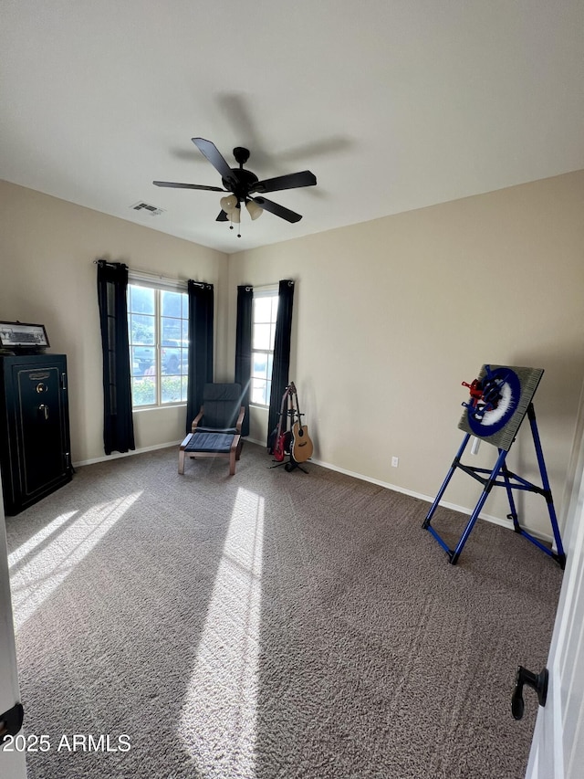 interior space featuring a ceiling fan, carpet, visible vents, and baseboards