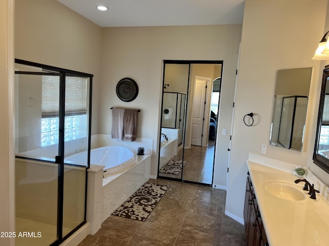 full bath with baseboards, a garden tub, vanity, and a shower stall