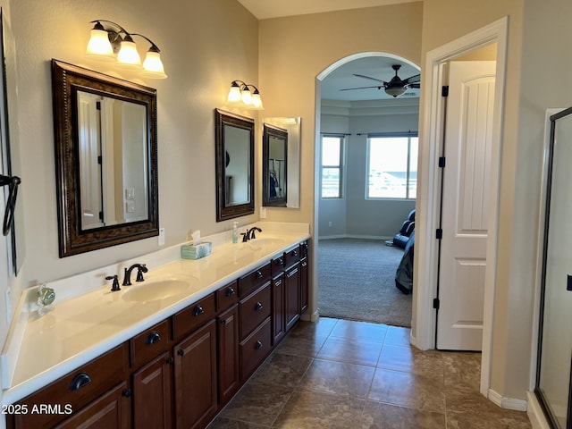 bathroom with double vanity, baseboards, a ceiling fan, and a sink