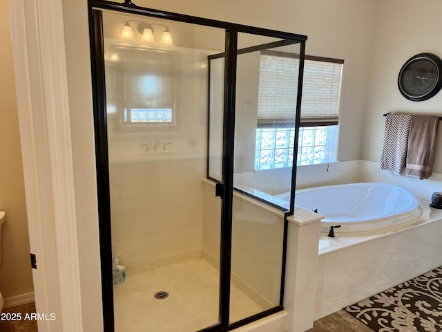 bathroom featuring toilet, a shower stall, and a bath