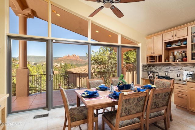 dining area with a healthy amount of sunlight, a mountain view, visible vents, and light tile patterned floors