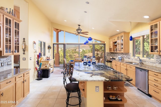 kitchen featuring tasteful backsplash, appliances with stainless steel finishes, a sink, and light brown cabinetry