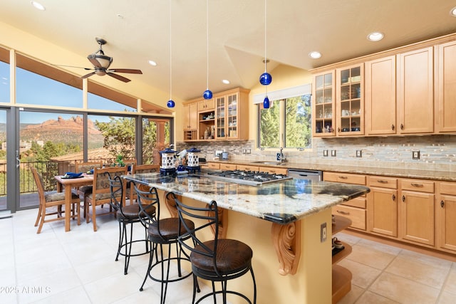 kitchen with decorative backsplash, lofted ceiling, a kitchen island, and a kitchen bar