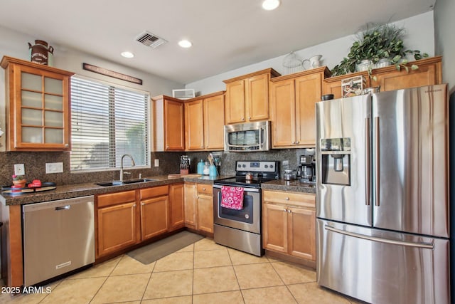 kitchen featuring light tile patterned flooring, stainless steel appliances, sink, and decorative backsplash