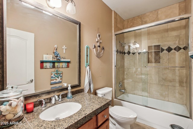 full bathroom with vanity, bath / shower combo with glass door, and toilet