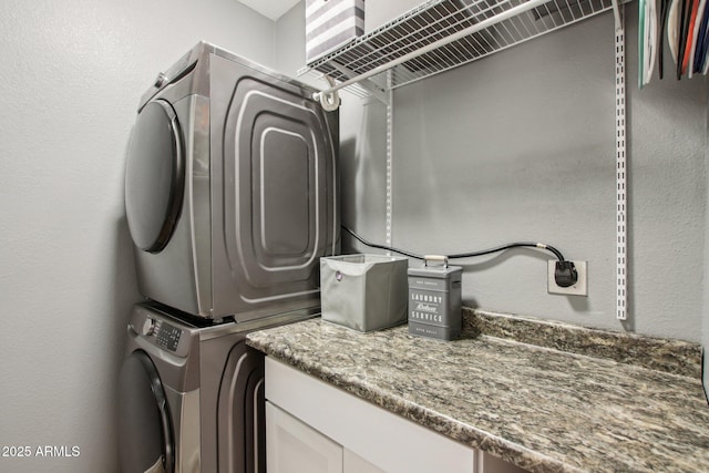 laundry area featuring stacked washer / drying machine