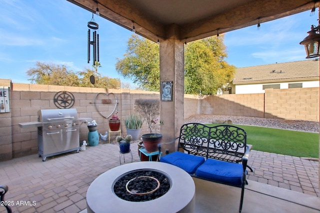 view of patio with area for grilling and an outdoor fire pit