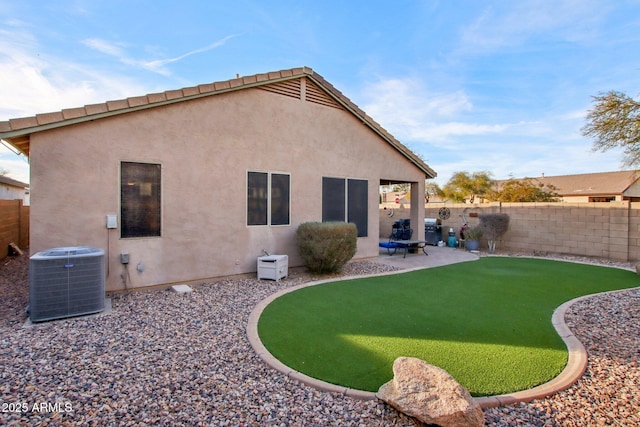 rear view of property featuring cooling unit, a patio area, and a lawn