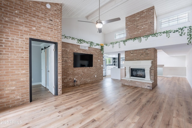 7800 E Lincoln Dr Unit 2029, Scottsdale, AZ 85250 - unfurnished living room with high vaulted ceiling, a ceiling fan, a large fireplace, wood finished floors, and beam ceiling
