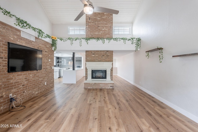 7800 E Lincoln Dr Unit 2029, Scottsdale, AZ 85250 - unfurnished living room featuring ceiling fan, a glass covered fireplace, light wood finished floors, baseboards, and high vaulted ceiling
