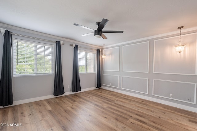 7800 E Lincoln Dr Unit 2029, Scottsdale, AZ 85250 - spare room featuring crown molding, light wood-style flooring, ceiling fan, baseboards, and a decorative wall