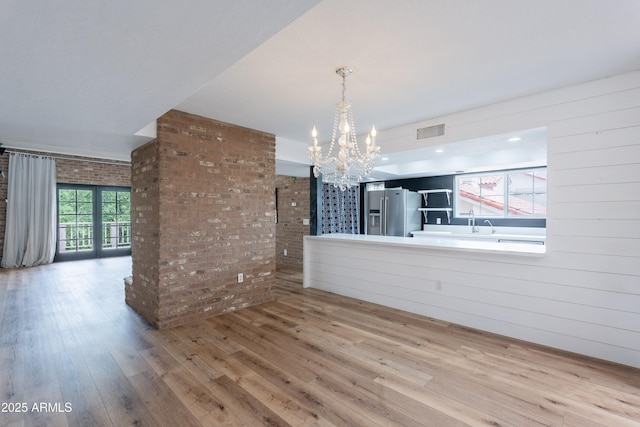 7800 E Lincoln Dr Unit 2029, Scottsdale, AZ 85250 - unfurnished dining area with wood finished floors, a chandelier, and brick wall