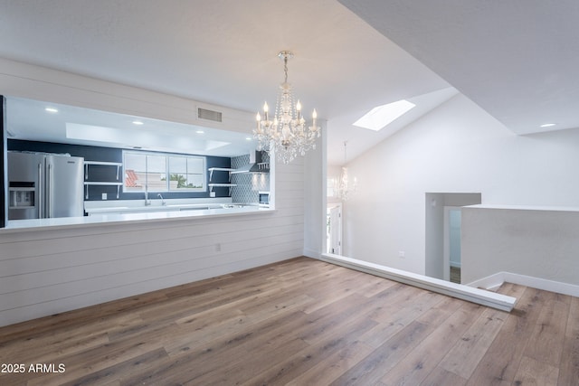 7800 E Lincoln Dr Unit 2029, Scottsdale, AZ 85250 - unfurnished dining area with a chandelier, a skylight, wood finished floors, baseboards, and a sink