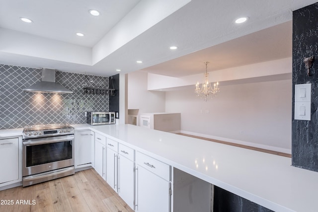 7800 E Lincoln Dr Unit 2029, Scottsdale, AZ 85250 - kitchen with appliances with stainless steel finishes, wall chimney range hood, light wood finished floors, backsplash, and recessed lighting