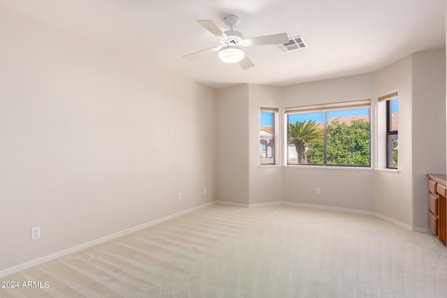 carpeted spare room featuring ceiling fan