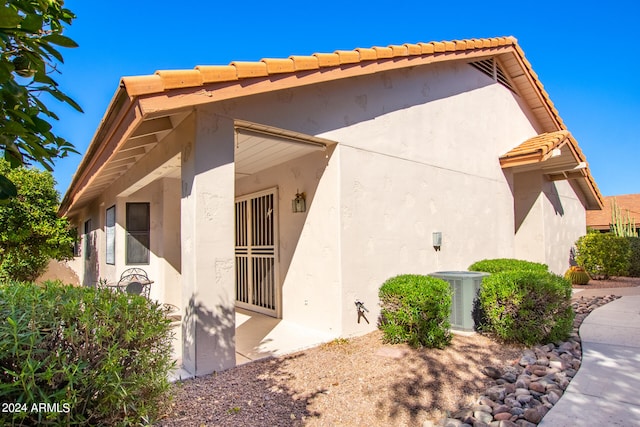 view of side of home with central air condition unit