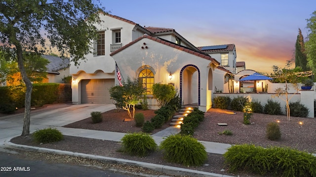 2985 N Point Ridge Rd, Buckeye, AZ 85396 - mediterranean / spanish-style house with a tile roof, driveway, stucco siding, and an attached garage