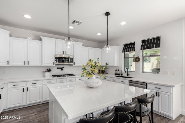 2985 N Point Ridge Rd, Buckeye, AZ 85396 - kitchen featuring stainless steel microwave, a sink, a kitchen breakfast bar, white cabinets, and recessed lighting