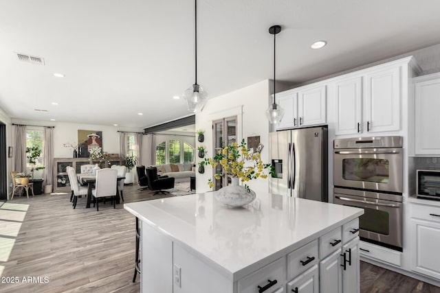 2985 N Point Ridge Rd, Buckeye, AZ 85396 - kitchen featuring stainless steel appliances, healthy amount of natural light, white cabinets, open floor plan, and recessed lighting