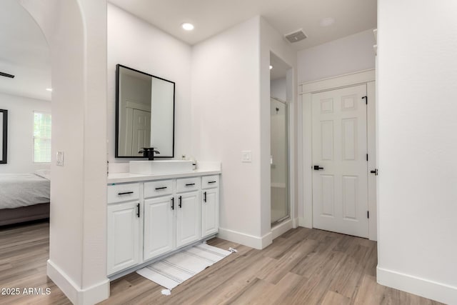 2985 N Point Ridge Rd, Buckeye, AZ 85396 - ensuite bathroom featuring wood finished floors, baseboards, a shower stall, and vanity