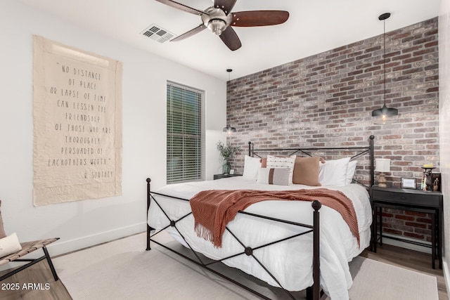 2985 N Point Ridge Rd, Buckeye, AZ 85396 - bedroom with brick wall, baseboards, a ceiling fan, and wood finished floors