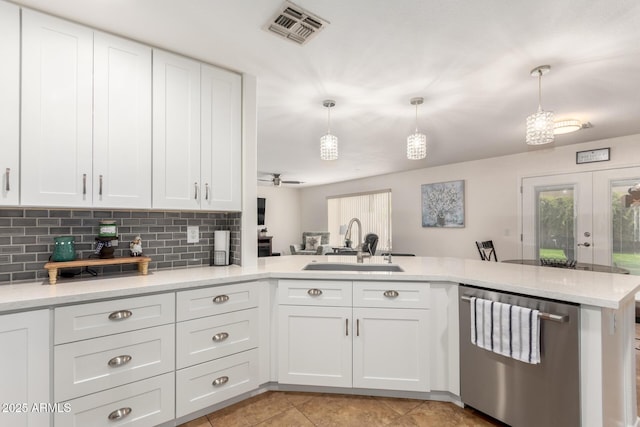 kitchen featuring visible vents, a sink, white cabinetry, decorative backsplash, and dishwasher