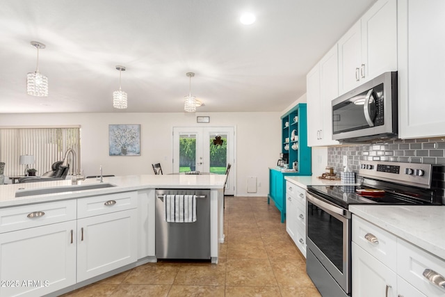 kitchen featuring a sink, french doors, appliances with stainless steel finishes, light countertops, and decorative backsplash