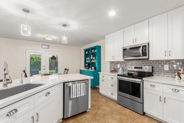 kitchen featuring a sink, decorative backsplash, light countertops, white cabinets, and appliances with stainless steel finishes