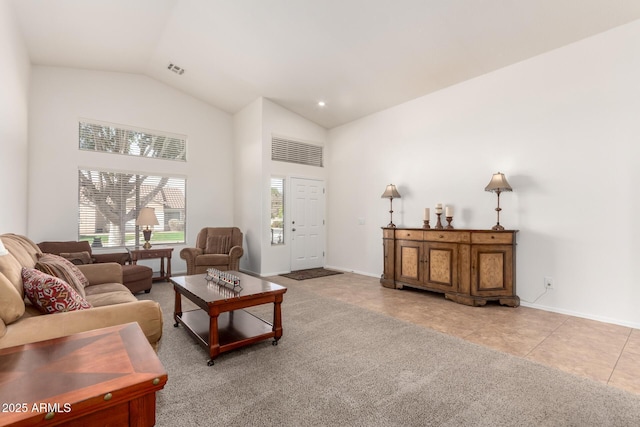 living room with tile patterned floors, visible vents, high vaulted ceiling, and baseboards