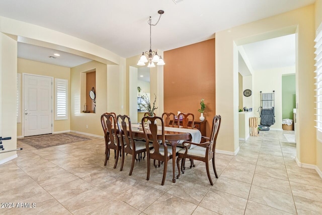 tiled dining area featuring an inviting chandelier