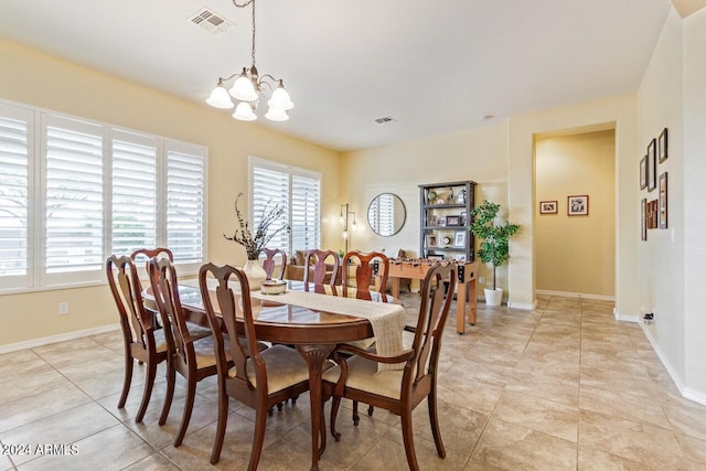 tiled dining space featuring an inviting chandelier