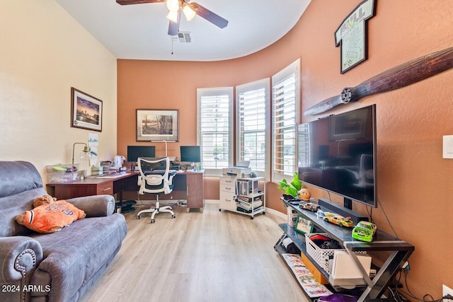 home office with light hardwood / wood-style flooring and ceiling fan