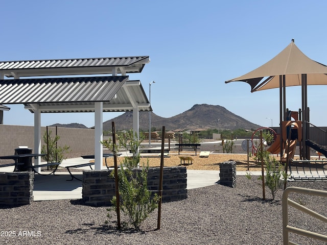 exterior space featuring playground community, a patio area, fence, and a mountain view