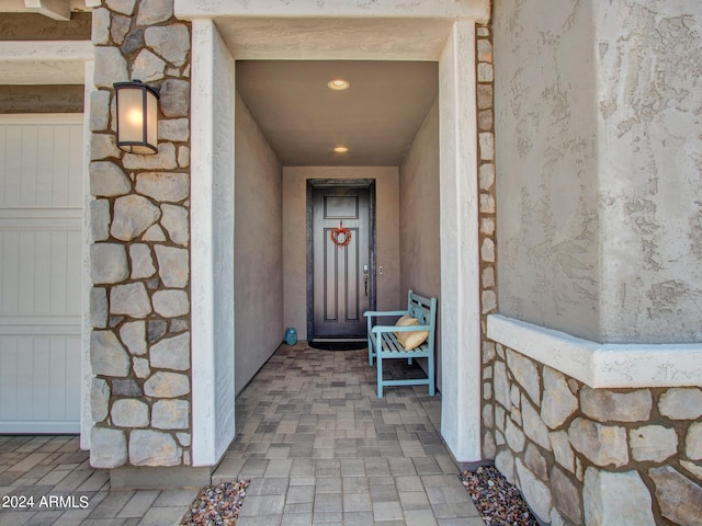 property entrance with stone siding and stucco siding