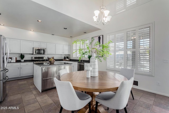 dining area with sink and a notable chandelier