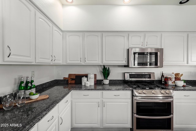 kitchen featuring white cabinets, dark stone countertops, and appliances with stainless steel finishes