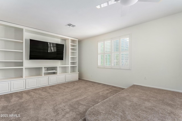 unfurnished living room featuring ceiling fan and carpet