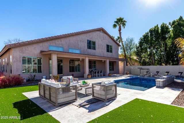 back of property featuring a swimming pool with hot tub, a patio area, a yard, and an outdoor living space