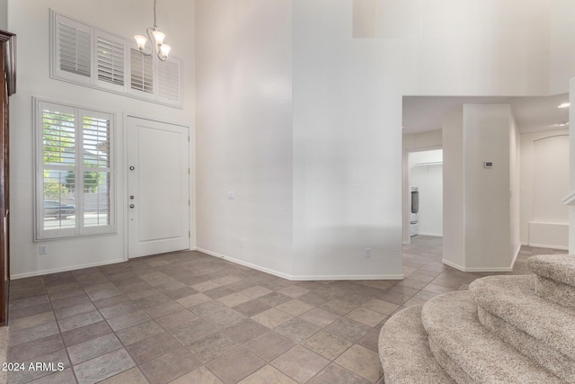 entryway featuring a towering ceiling and a chandelier