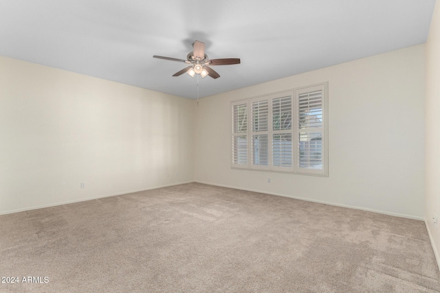 carpeted spare room featuring ceiling fan