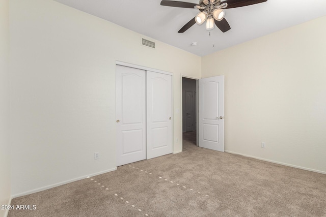 unfurnished bedroom with light colored carpet, a closet, and ceiling fan