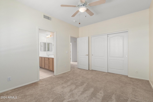 unfurnished bedroom featuring a closet, ceiling fan, connected bathroom, and light carpet