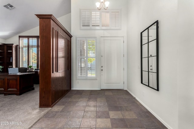 carpeted foyer with a chandelier and lofted ceiling