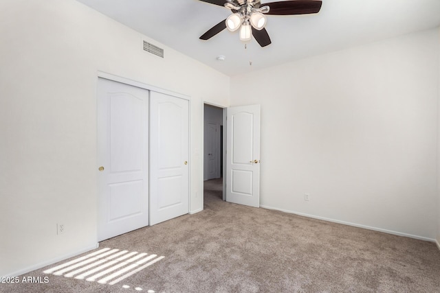 unfurnished bedroom featuring ceiling fan, light colored carpet, and a closet