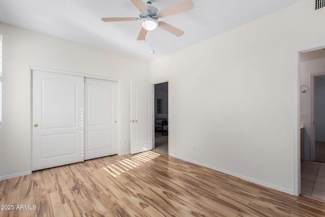 unfurnished bedroom featuring a closet, ceiling fan, and light hardwood / wood-style flooring