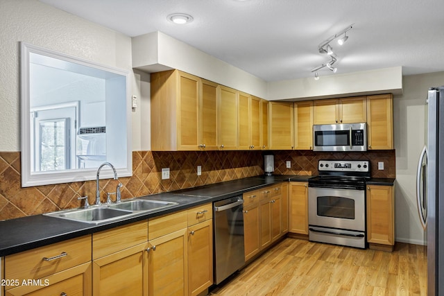 1832 E Concorda Dr, Tempe, AZ 85282 - kitchen with stainless steel appliances, a sink, light wood-style floors, dark countertops, and backsplash