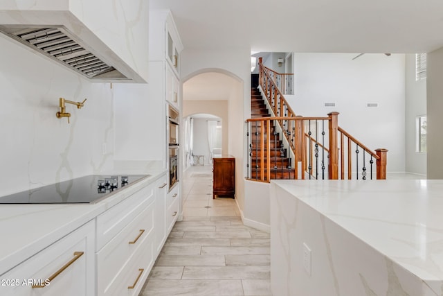 interior space featuring stairway, arched walkways, and visible vents