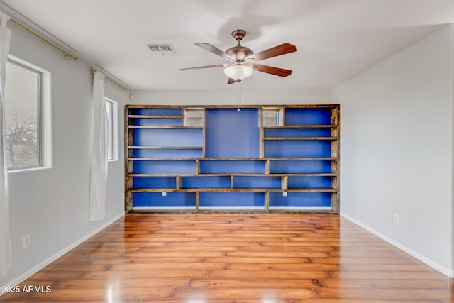 unfurnished bedroom featuring visible vents, ceiling fan, baseboards, and wood finished floors