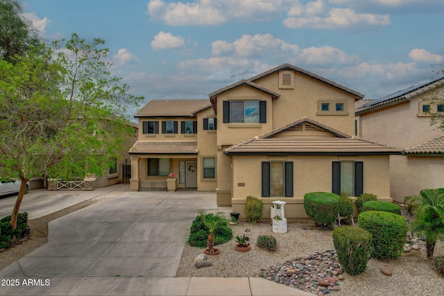 view of front of home featuring stucco siding, driveway, and a tile roof